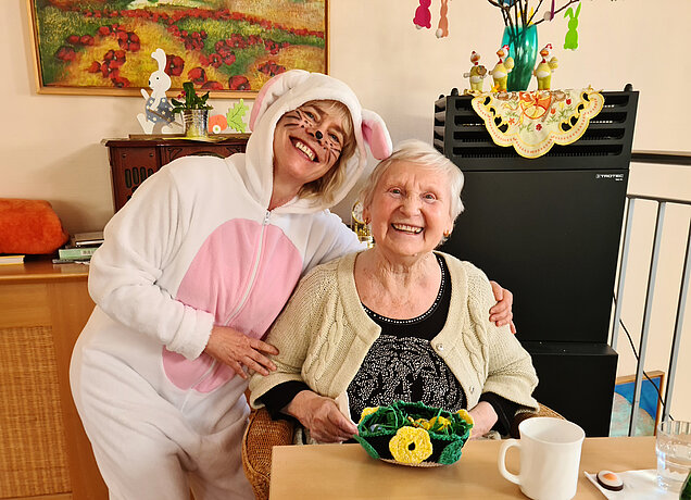 Zwei Frauen lachen in die Kamera, eine trägt ein Hasenkostüm
