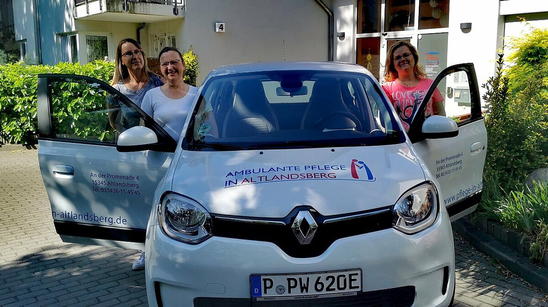 Foto mit Dienstfahrzeug und Mitarbeitenden