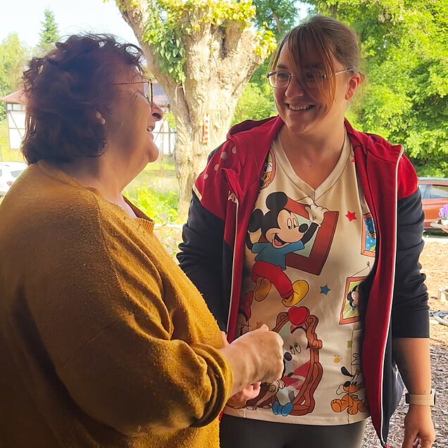 Zwei Frauen unterhalten sich auf einer Terrasse