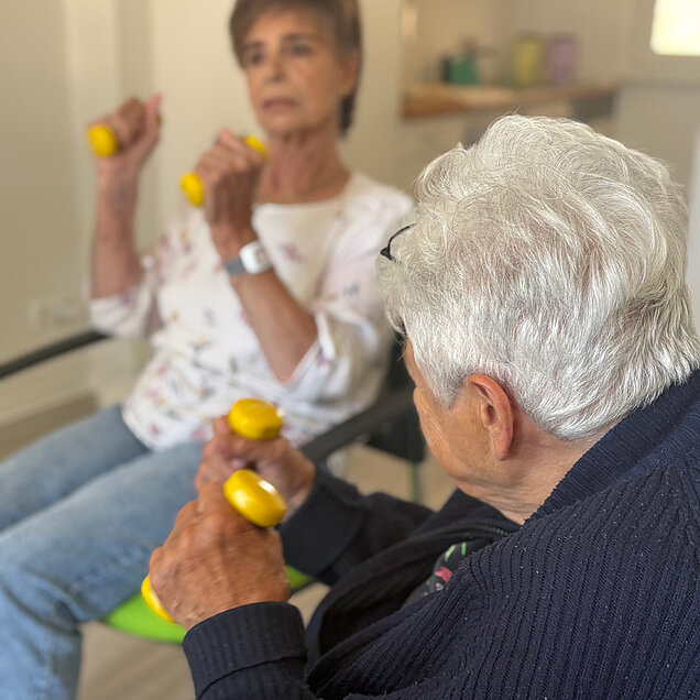 Zwei ältere Menschen mit Gewichten in der Hand