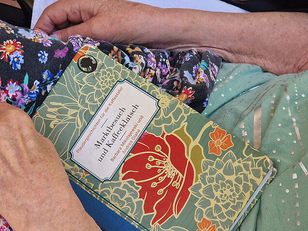 Frau hält Buch auf Ihrem Schoß