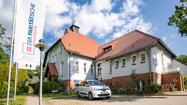 Seniorenresidenz Altlandsberg mit Pflegedienst-Auto auf Parkplatz vor dem Haus