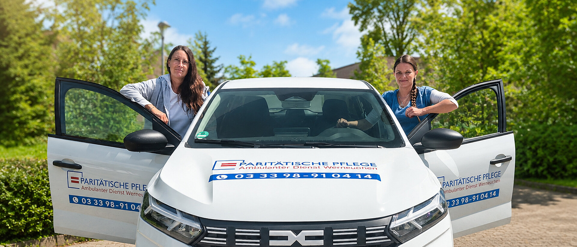 Zwei Mitarbeiterinnen stehen rechts und links an den geöffneten Autotüren eines Fahrzeugs der ambulanten Pflege